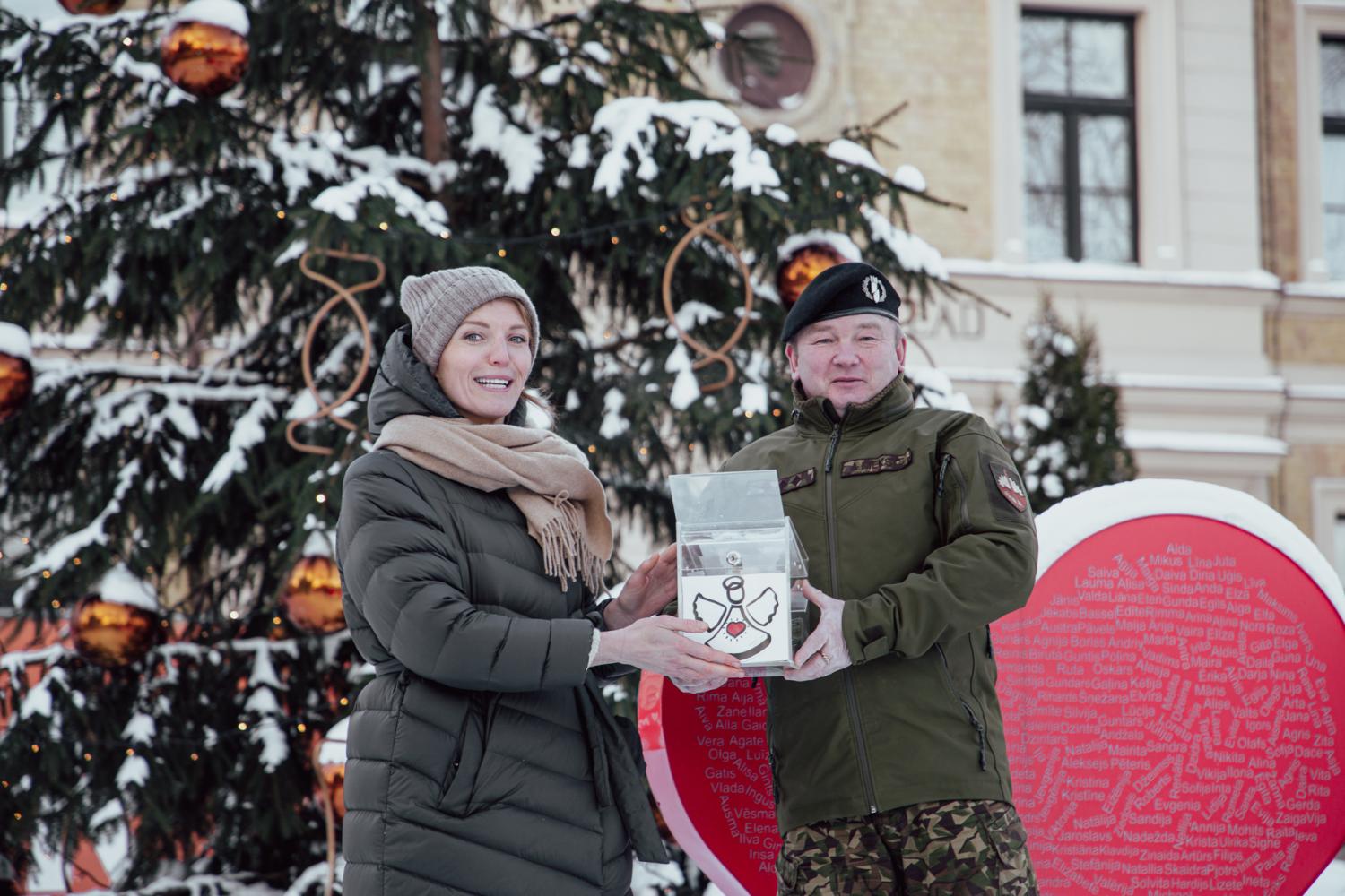 Zemessardzes 4. Kurzemes brigādes komandieris pulkvedis Andris Rieksts pasniedz ziedojumu kastīti Bērnu slimnīcas fonda labdarības akcijai “Eņģeļi pār Latviju”  pārstāvei