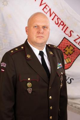 Pulkvežleitnanta Jāņa Lakševica portrets svētku formastērpā uz Zemessardzes 46. kājnieku bataljona karoga fona