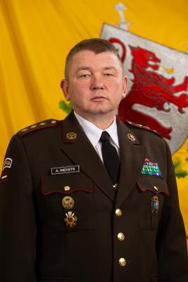 Pulkveža Andra Rieksta portrets svētku formastērpā uz Zemessardzes 4. Kurzemes brigādes fona