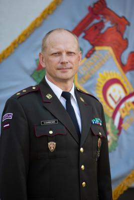 Pulkvežleitnanta Viktora Karecka portrets svētku formastērpā uz Zemessardzes 44. kājnieku bataljona karoga fona