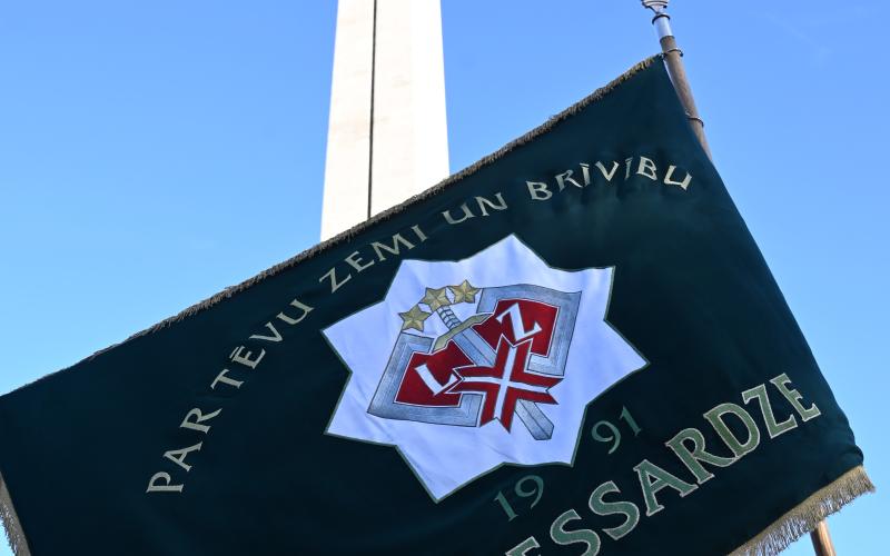 Zemessardzes karogs uz Brīvības pieminekļa fona